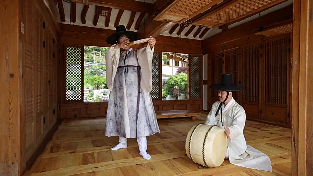 在韩国风格的房子里和鼓手一起唱盘索里(一种由歌手和鼓手表演的韩国音乐故事类型)的歌手视频素材