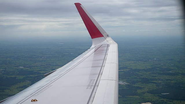 飞机飞行。机翼上的一架飞机在云端飞行，从窗口俯视飞机视频素材