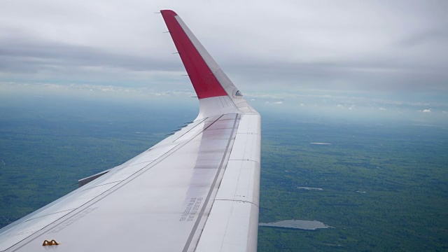 飞机飞行。机翼上的一架飞机在云端飞行，从窗口俯视飞机视频素材
