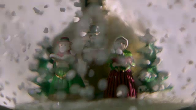 穿着维多利亚时代服装的塑料颂歌歌手们在一个雪球里迎接“暴风雪”。视频下载