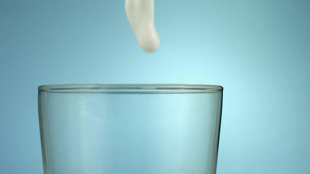 牛奶倒入玻璃杯，慢动作视频素材