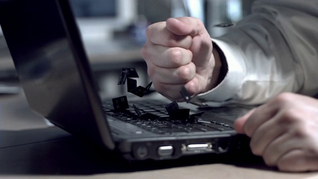 商人用拳头砸笔记本电脑，慢动作视频素材