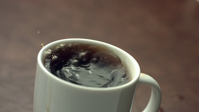 方糖溅到咖啡杯里，慢镜头视频素材
