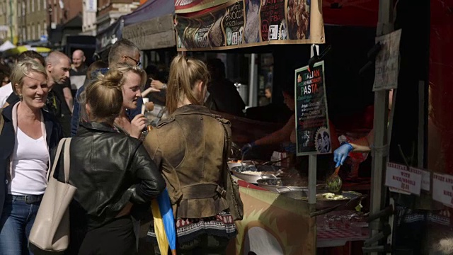 在英国伦敦的一个市场上，人们吃着街头小吃。视频下载