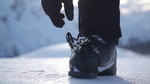 滑雪靴女滑雪场中准备在雪地上滑雪的妇女——慢动作视频下载