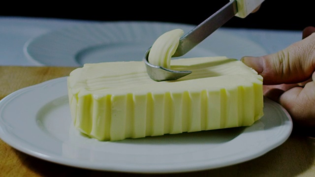 用刀在白色盘子上搅拌黄油的超级慢镜头(特写)视频下载