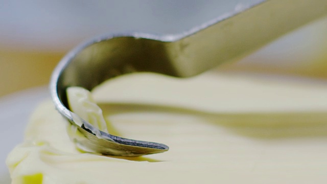用刀在白色盘子上搅拌黄油的超级慢镜头(特写)视频下载