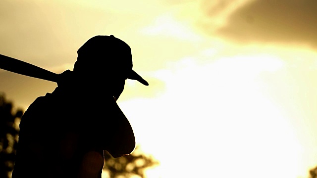 男子棒球练习在夕阳下击球视频素材