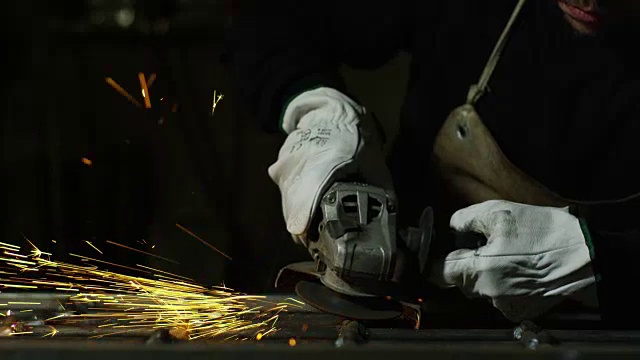 铁匠或焊工，用其磨光钢和铁，以极慢的动作，使表面光滑。砂轮与铁接触时会产生火花。视频素材