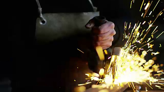 铁匠或焊工，用其磨光钢和铁，以极慢的动作，使表面光滑。砂轮与铁接触时会产生火花。视频素材