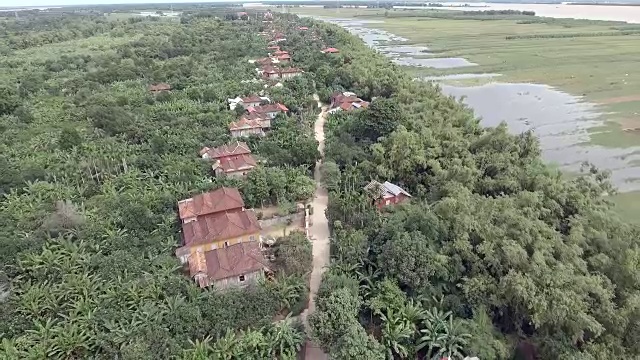航拍:飞回显示一条穿过亚洲村的漫长道路视频素材