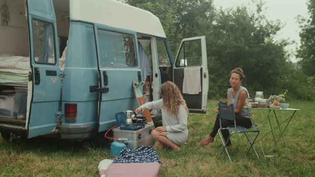 美丽的女人在一辆面包车里做早餐/在早上露营视频素材