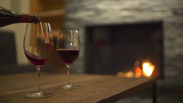在一家豪华度假村的餐厅里，红酒倒进玻璃杯和壁炉里。视频素材