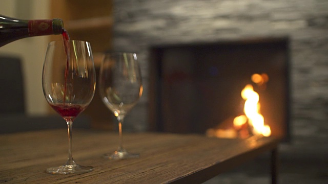 在一家豪华度假村的餐厅里，红酒倒进玻璃杯和壁炉里。视频素材