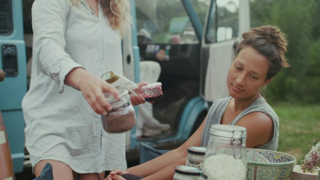 美丽的女人在一辆面包车里做早餐/在早上露营视频素材