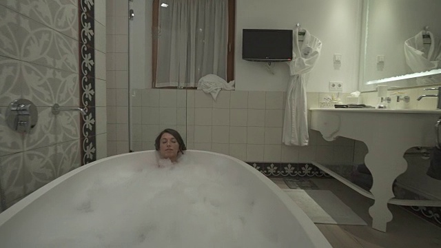 一名女子在豪华度假胜地的浴缸中享受泡泡浴。视频素材