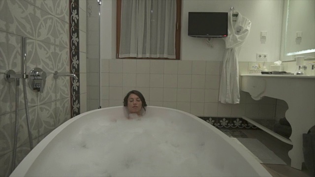 一名女子在豪华度假胜地的浴缸中享受泡泡浴。视频素材
