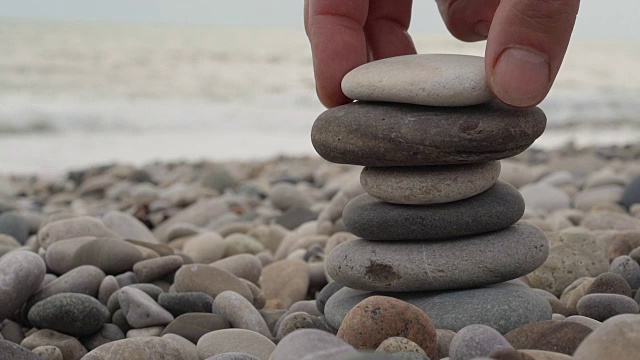 在海滩上手工堆砌一堆石头视频素材