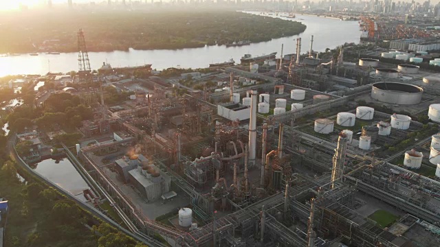 鸟瞰图炼油厂或化工厂站在大河边，以曼谷为背景的傍晚。视频素材