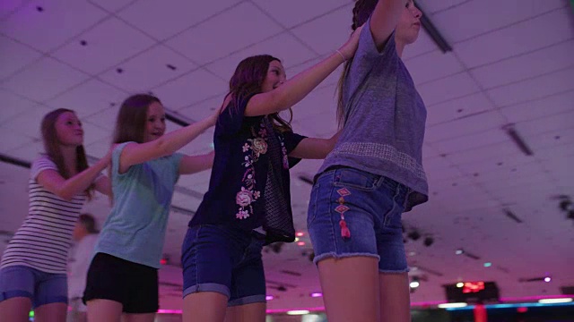 女孩们拿着肩膀在一排滑冰的慢动作镜头/ Orem，犹他州，美国视频素材