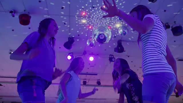 女孩们在迪斯科球下的轮滑溜冰场跳舞和唱歌，美国犹他州视频素材