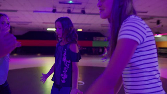 女孩跳舞和唱歌在轮滑溜冰场/ Orem，美国犹他州的慢动作视频素材