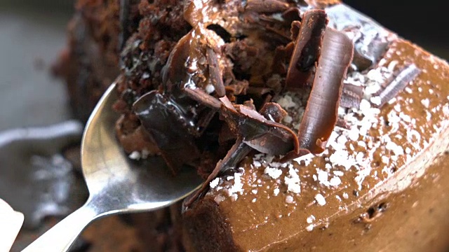 倾斜切割巧克力蛋糕近距离。视频下载
