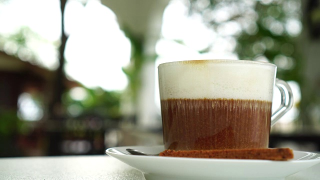 热咖啡杯，咖啡桌上的咖啡拿铁艺术:4k视频素材