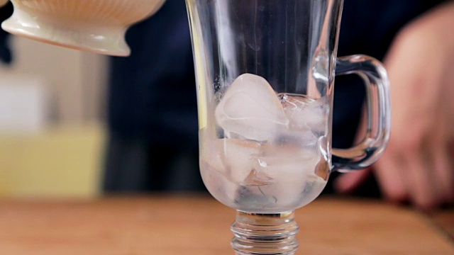 水壶将泰国冰茶倒入玻璃杯中视频下载