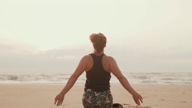 日落时分，年轻女子在法国海滩上练习瑜伽视频素材