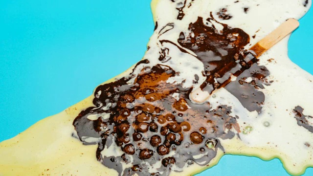 巧克力外冰棒与豆融化在蓝色背景时间流逝视频素材