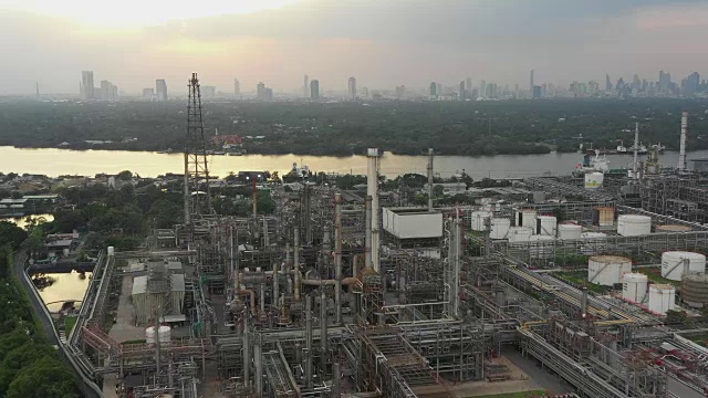 鸟瞰图炼油厂或化工厂站在大河边，以曼谷为背景的傍晚。视频素材