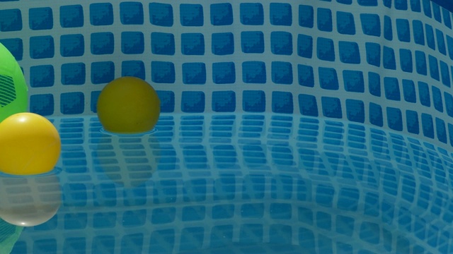 不同颜色的球漂浮在一个小水池的水视频下载