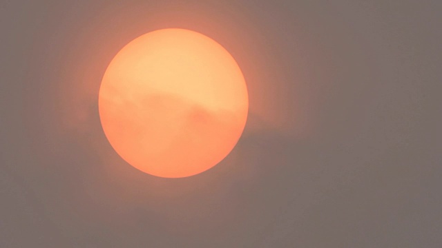 阳光被撒哈拉沙漠的尘土和从左向右移动的野火烟雾所遮蔽。视频素材