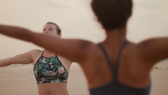 日落时分，两个女人在法国的海滩上练习瑜伽/冥想视频下载