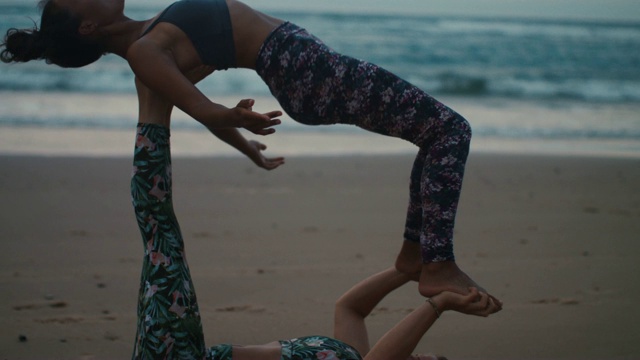 两个女人在海滩上练习acroyoga黄昏/黎明在大西洋海滩在法国视频素材