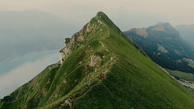 女人在瑞士阿尔卑斯山的山脊上跑步的鸟瞰图视频素材