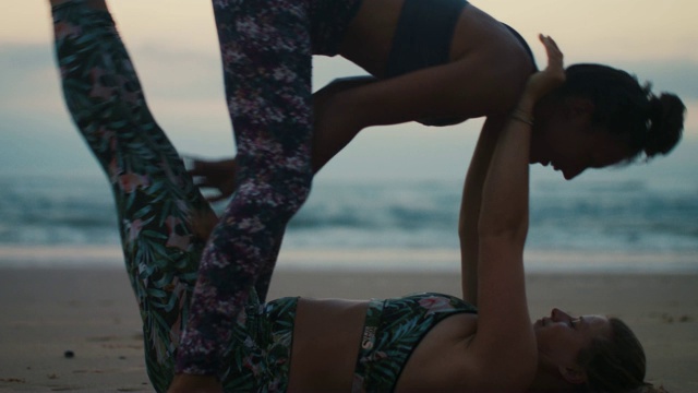 两个女人在海滩上练习acroyoga黄昏/黎明在大西洋海滩在法国视频素材