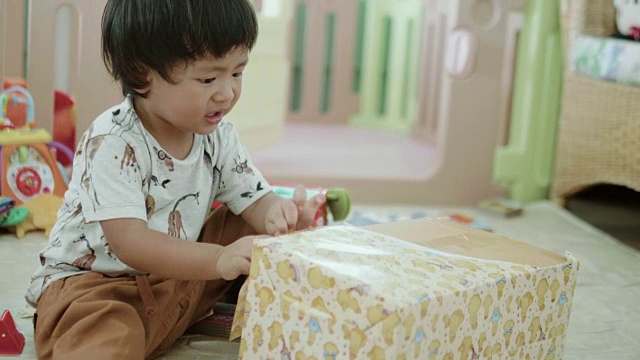 微笑的男孩打开生日礼盒。视频素材