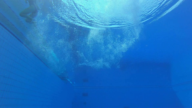 SLO MO LD一名女跳水运动员在水池中着陆的水下视图视频下载
