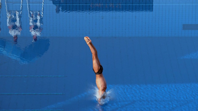 SLO MO男子运动员站起来，从跳板上起飞，跳水入池视频下载