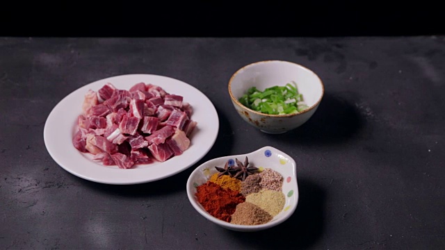在黑色木质背景上准备新鲜的生肉和制作咖喱的原料视频下载