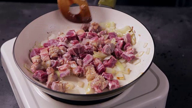 用洋葱煎锅煎炸的牛肉。牛肉是在煎锅里煮的。视频下载