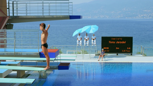男子跳水运动员在比赛中从跳板上弹跳并跳水入池视频下载
