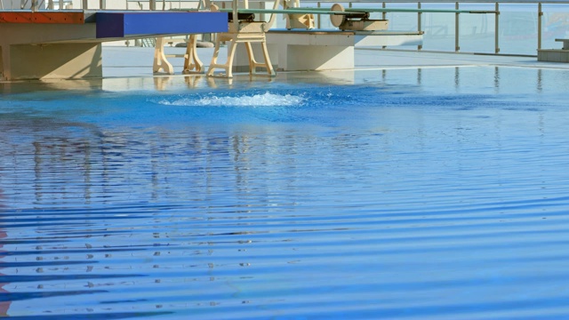 SLO MO女跳水运动员从阳光灿烂的跳台上跳下视频下载