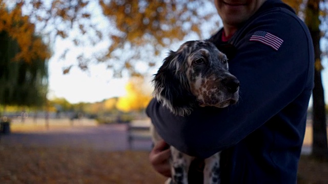 退伍军人在城市公园拥抱他的小狗视频素材