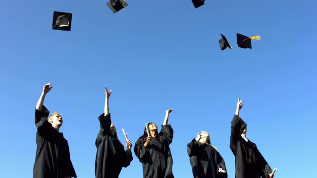 一群毕业生在扔毕业帽视频素材