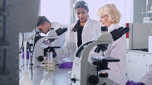 在实验室里使用显微镜的女科学家视频素材