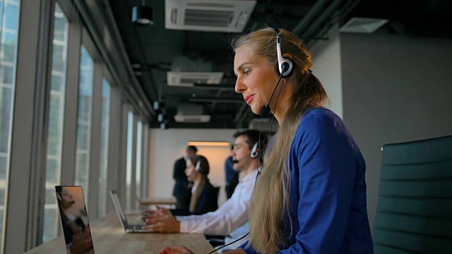 年轻的女员工喜欢通过耳机与客户交谈视频素材
