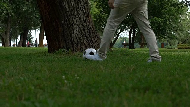 爸爸和儿子一起踢足球，习惯了孩子积极健康的生活方式视频下载